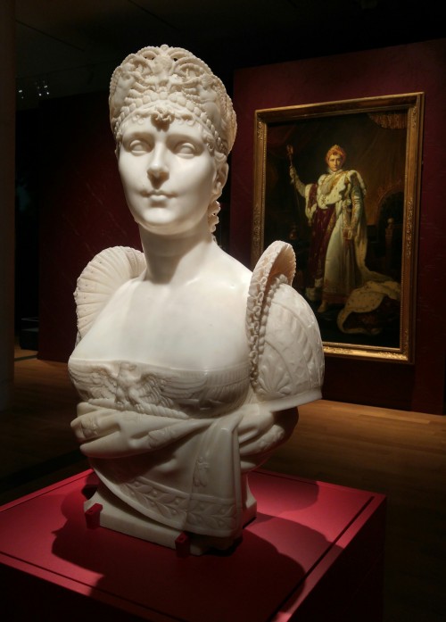 Marble bust of Josephine with a painting of Napoleon behind her.